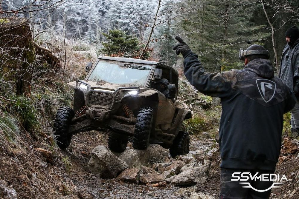 Le moniteur guide un SSV dans un passage rocheux lors d'un Raid Rocks